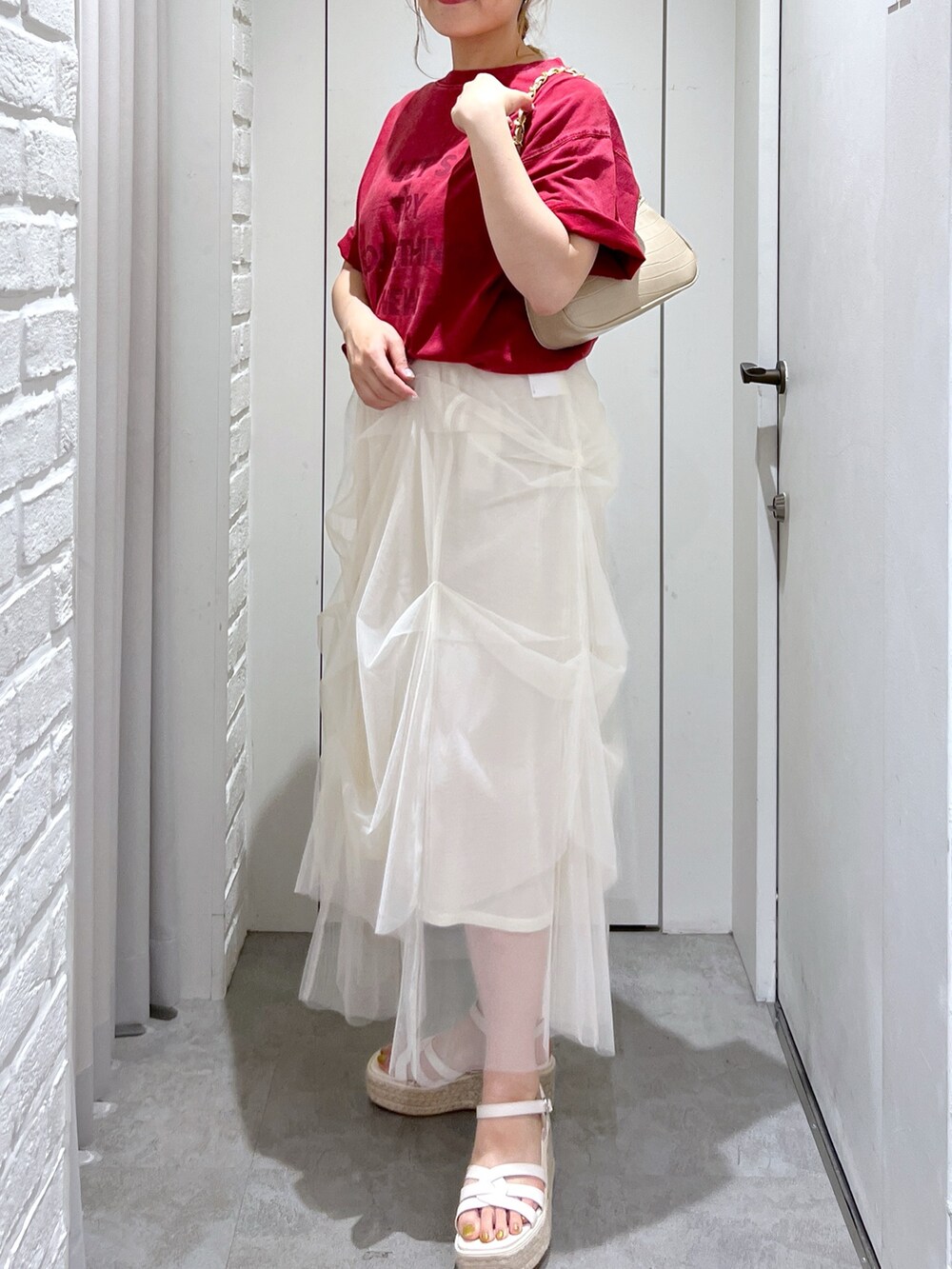 ホワイト系のスカート、レッド系のTシャツ/カットソー、ホワイト系のサンダルを着用したレディースの夏コーディネートの4枚目の写真