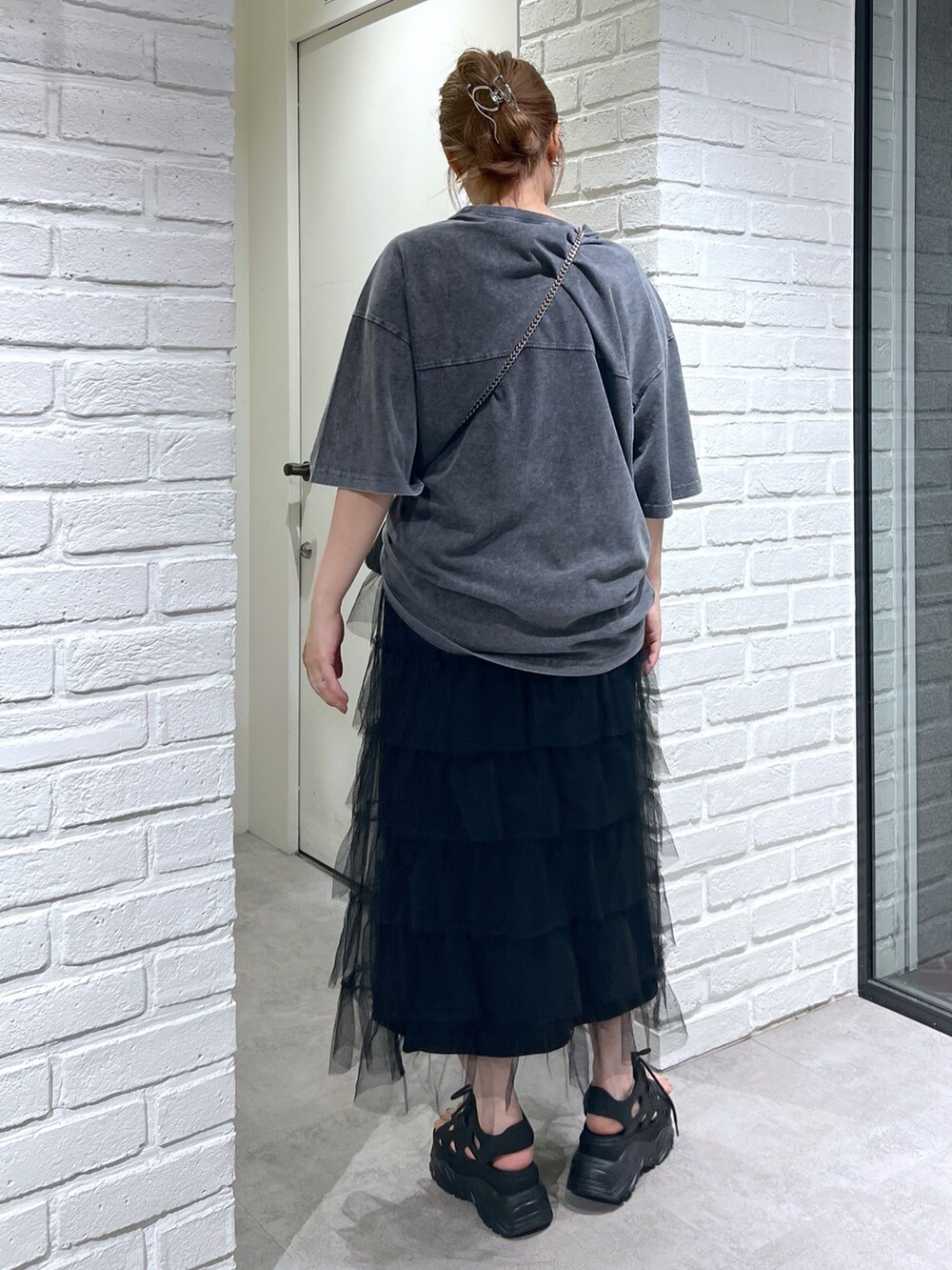 ブラック系のスカート、ブラック系のサンダル、ブラック系のショルダーバッグを着用したレディースの夏コーディネートの4枚目の写真