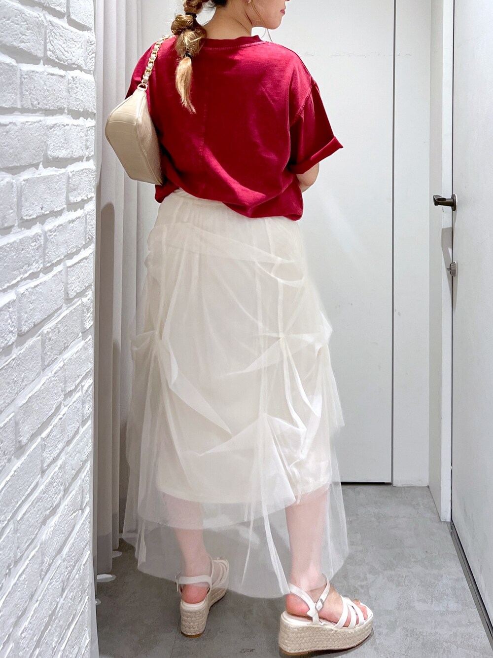 ホワイト系のスカート、レッド系のTシャツ/カットソー、ホワイト系のサンダルを着用したレディースの夏コーディネートの7枚目の写真