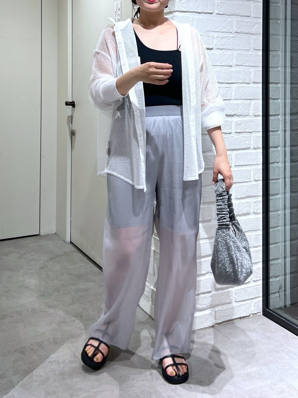 ホワイト系のシャツ/ブラウス、グレー系のその他パンツ、ブラック系のサンダルを着用したレディースの夏コーディネートの4枚目の写真