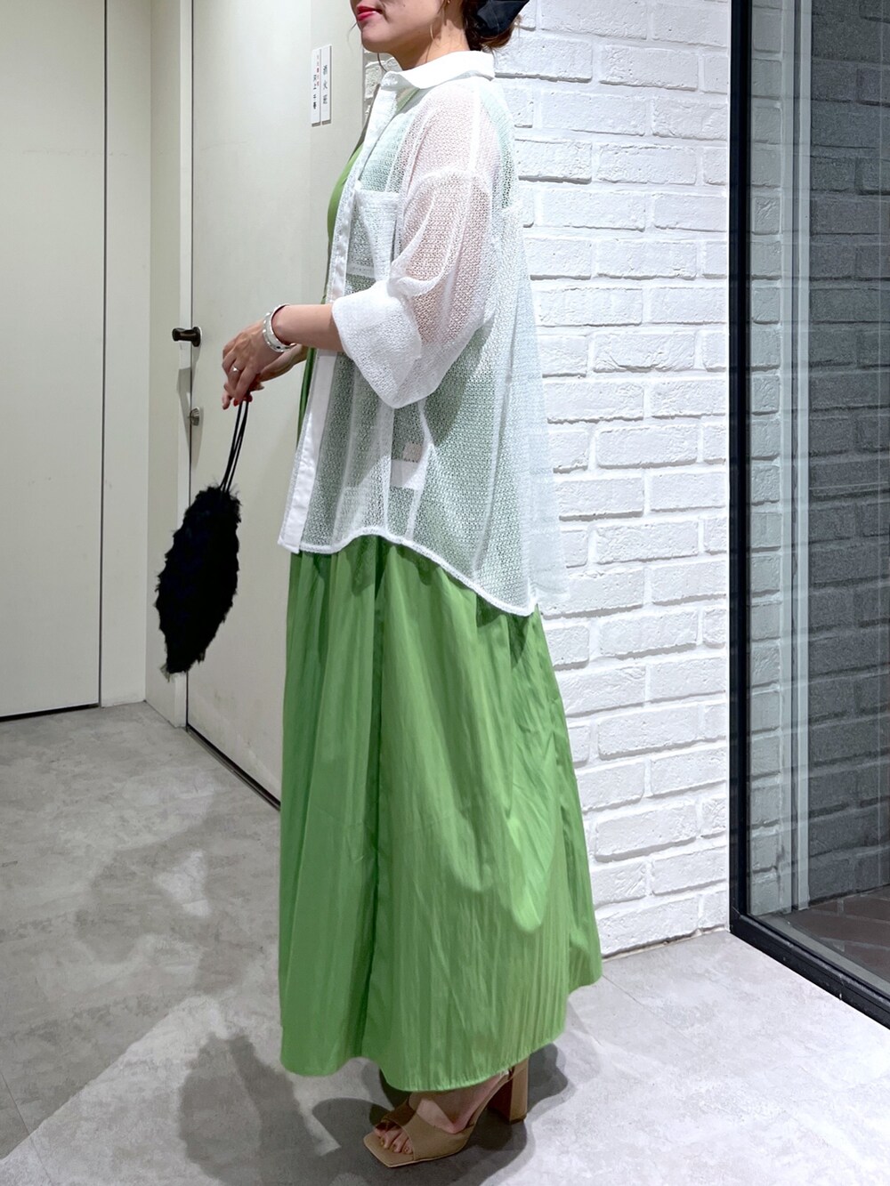 グリーン系のワンピース、ホワイト系のシャツ/ブラウス、ブラック系のハンドバッグを着用したレディースの夏コーディネートの7枚目の写真