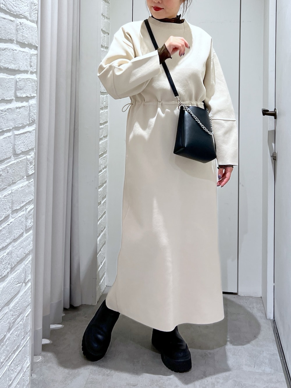 ホワイト系のワンピース、ブラック系のショルダーバッグ、ブラック系のTシャツ/カットソーを着用したレディースの冬コーディネートの5枚目の写真