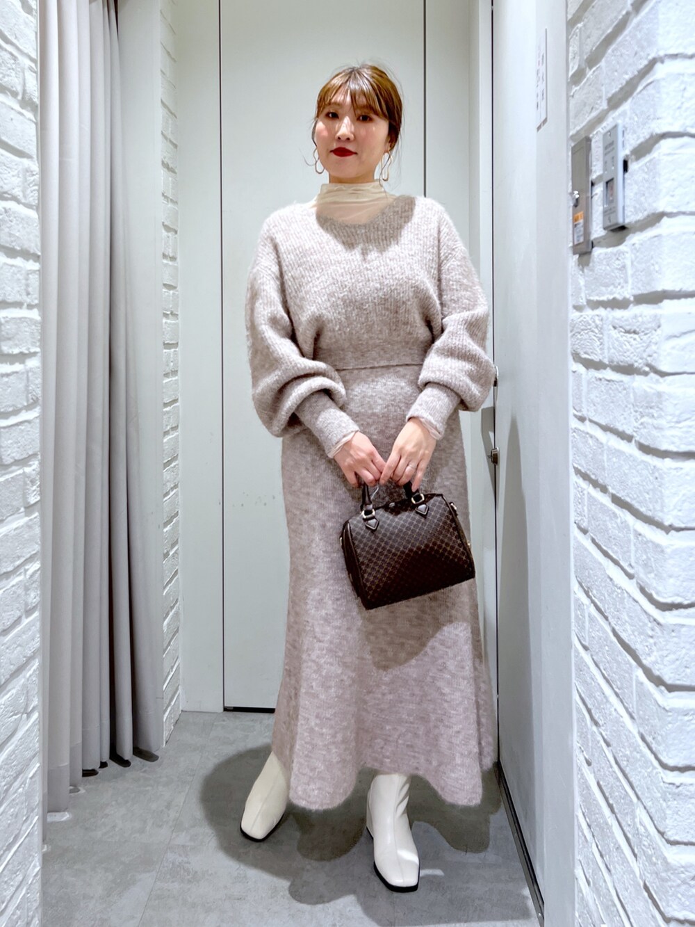 ベージュ系のスカート、ベージュ系のニット/セーター、ベージュ系のバッグを着用したレディースの冬コーディネートの2枚目の写真