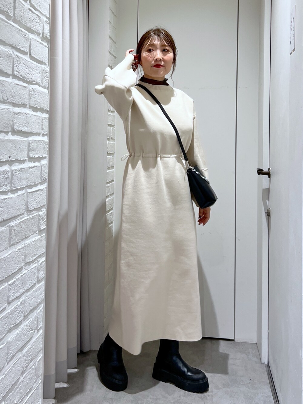 ホワイト系のワンピース、ブラック系のショルダーバッグ、ブラック系のTシャツ/カットソーを着用したレディースの冬コーディネートの2枚目の写真