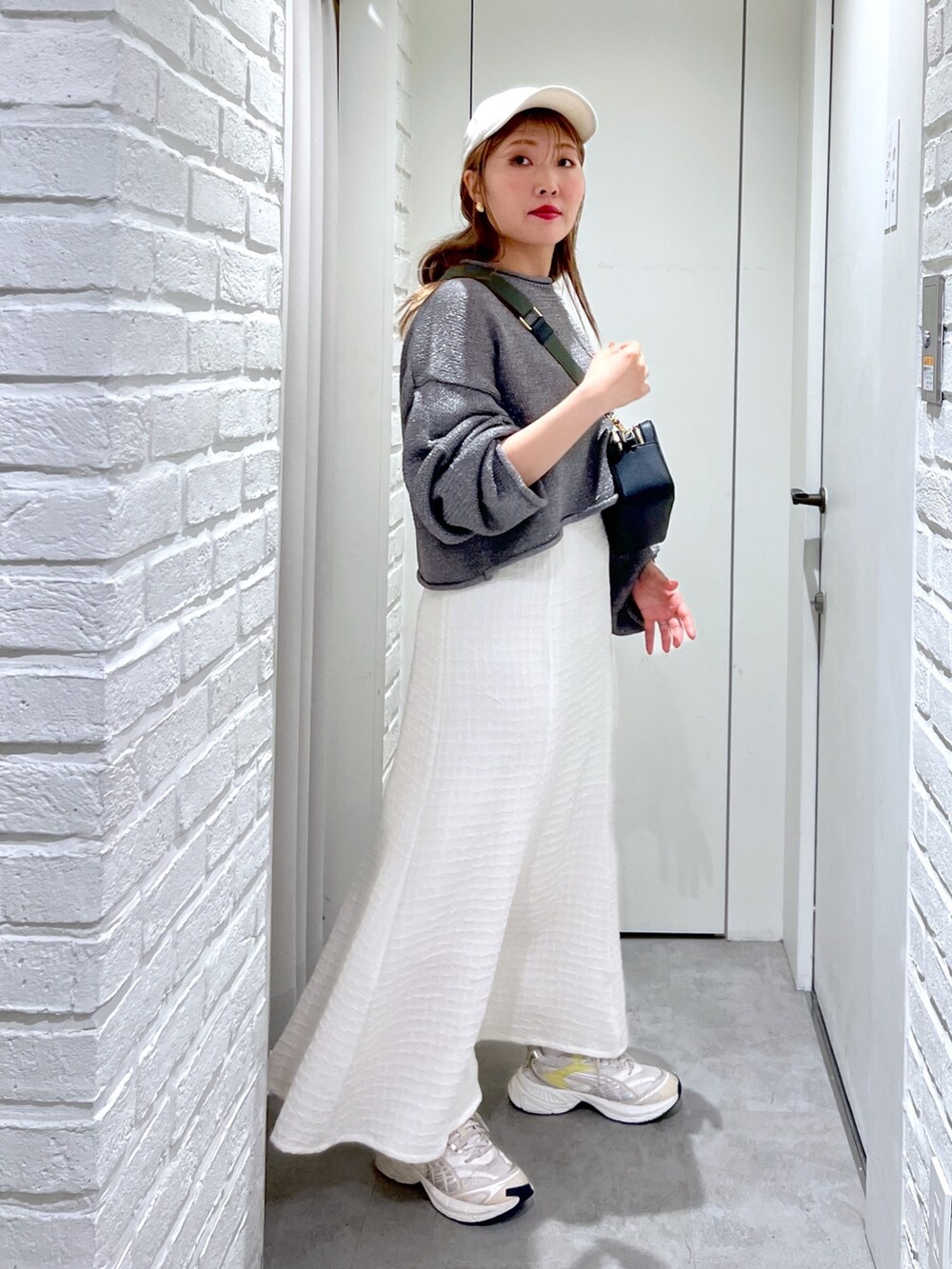 ホワイト系のワンピース、ブラック系のボディバッグ/ウエストポーチ、シルバー系のニット/セーターを着用したレディースの春コーディネートの3枚目の写真