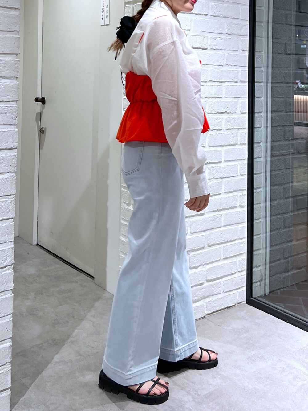 ブルー系のデニムパンツ、ブラック系のサンダル、レッド系のシャツ/ブラウスを着用したレディースの夏コーディネートの6枚目の写真