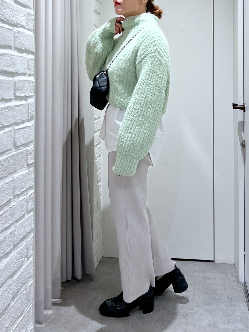 ホワイト系のシャツ/ブラウス、ホワイト系のその他パンツ、グリーン系のニット/セーターを着用したレディースの冬コーディネートの3枚目の写真
