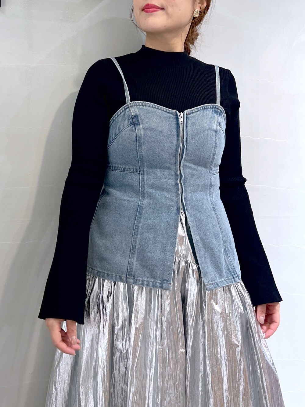 シルバー系のスカート、ブルー系のベスト、ブラック系のニット/セーターを着用したレディースの春コーディネートの8枚目の写真