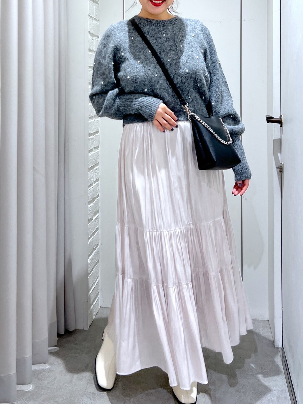 ホワイト系のスカート、グレー系のニット/セーター、ブラック系のショルダーバッグを着用したレディースの冬コーディネートの5枚目の写真