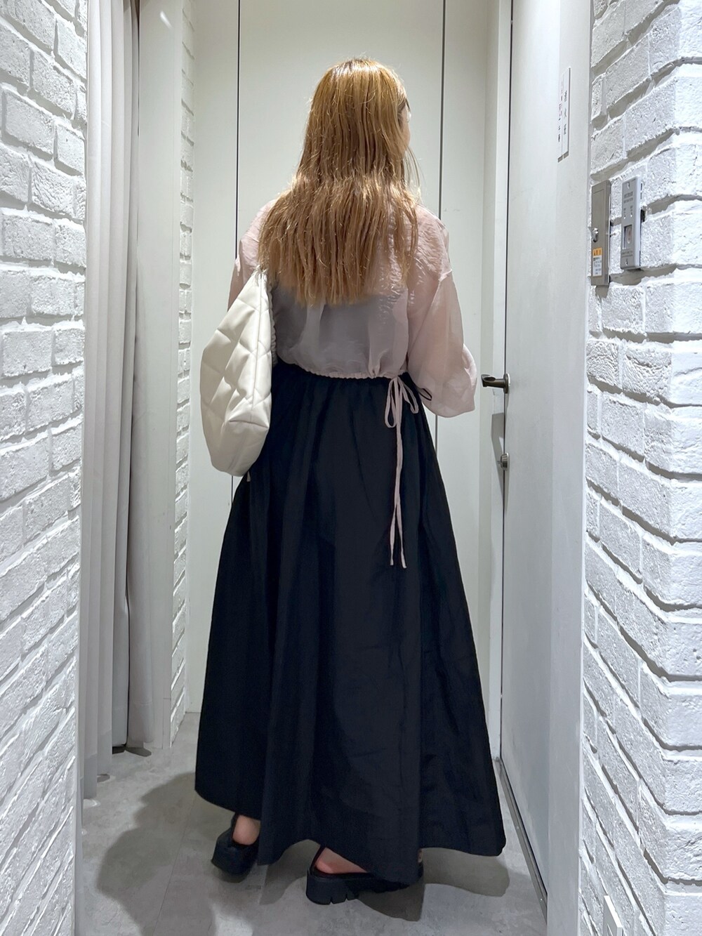 ブラック系のワンピース、ホワイト系のトートバッグ、ピンク系のシャツ/ブラウスを着用したレディースの夏コーディネートの6枚目の写真