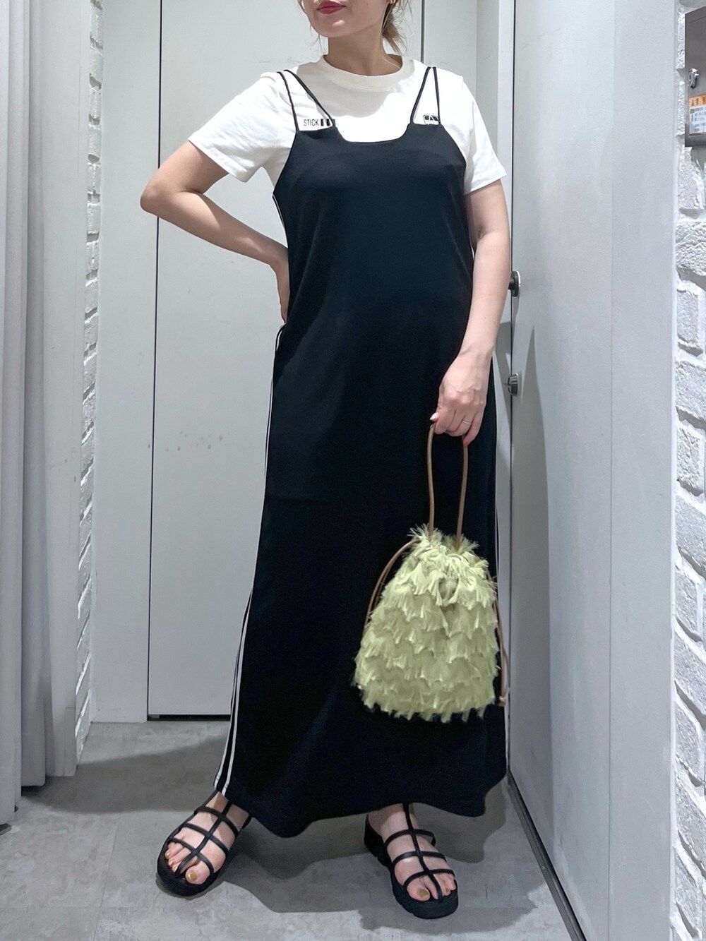 ブラック系のワンピース、ホワイト系のTシャツ/カットソー、ブラック系のサンダルを着用したレディースの夏コーディネートの4枚目の写真