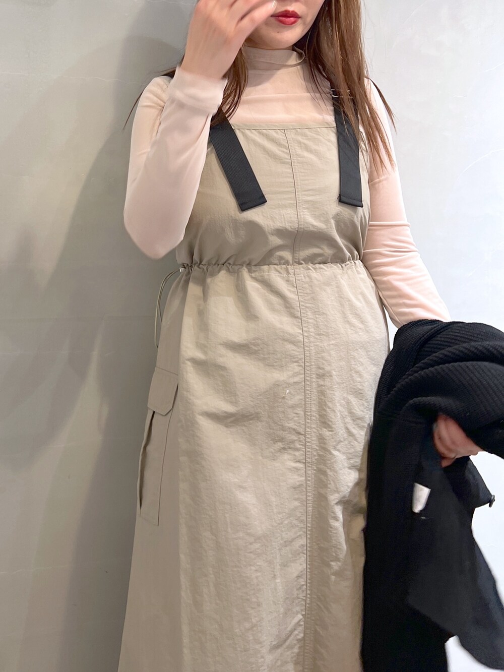 ベージュ系のワンピース、ブラック系のトートバッグ、ブラック系のカーディガン/ボレロを着用したレディースの冬コーディネートの6枚目の写真