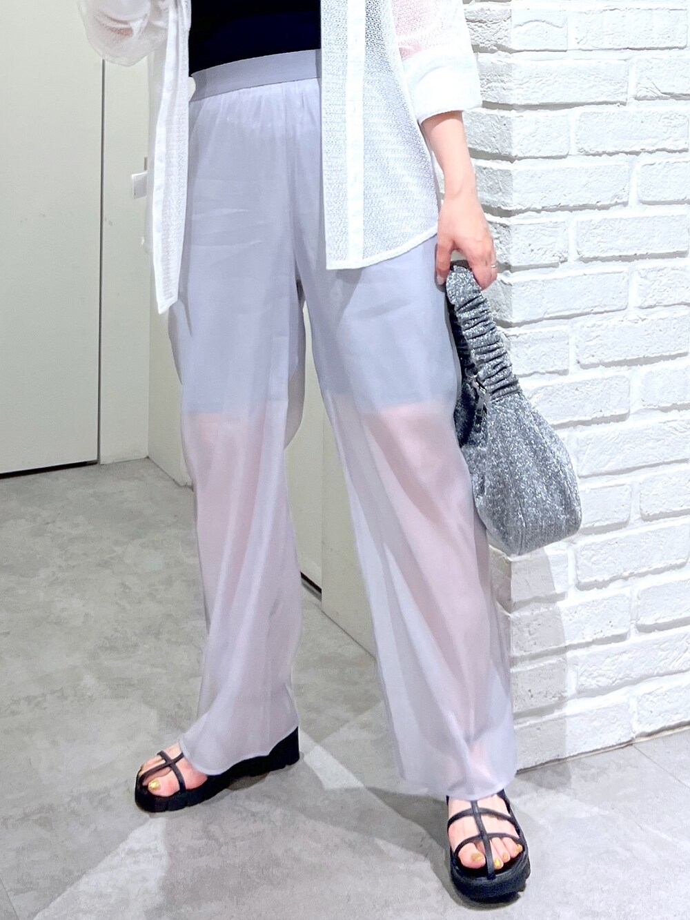 ホワイト系のシャツ/ブラウス、グレー系のその他パンツ、ブラック系のサンダルを着用したレディースの夏コーディネートの6枚目の写真