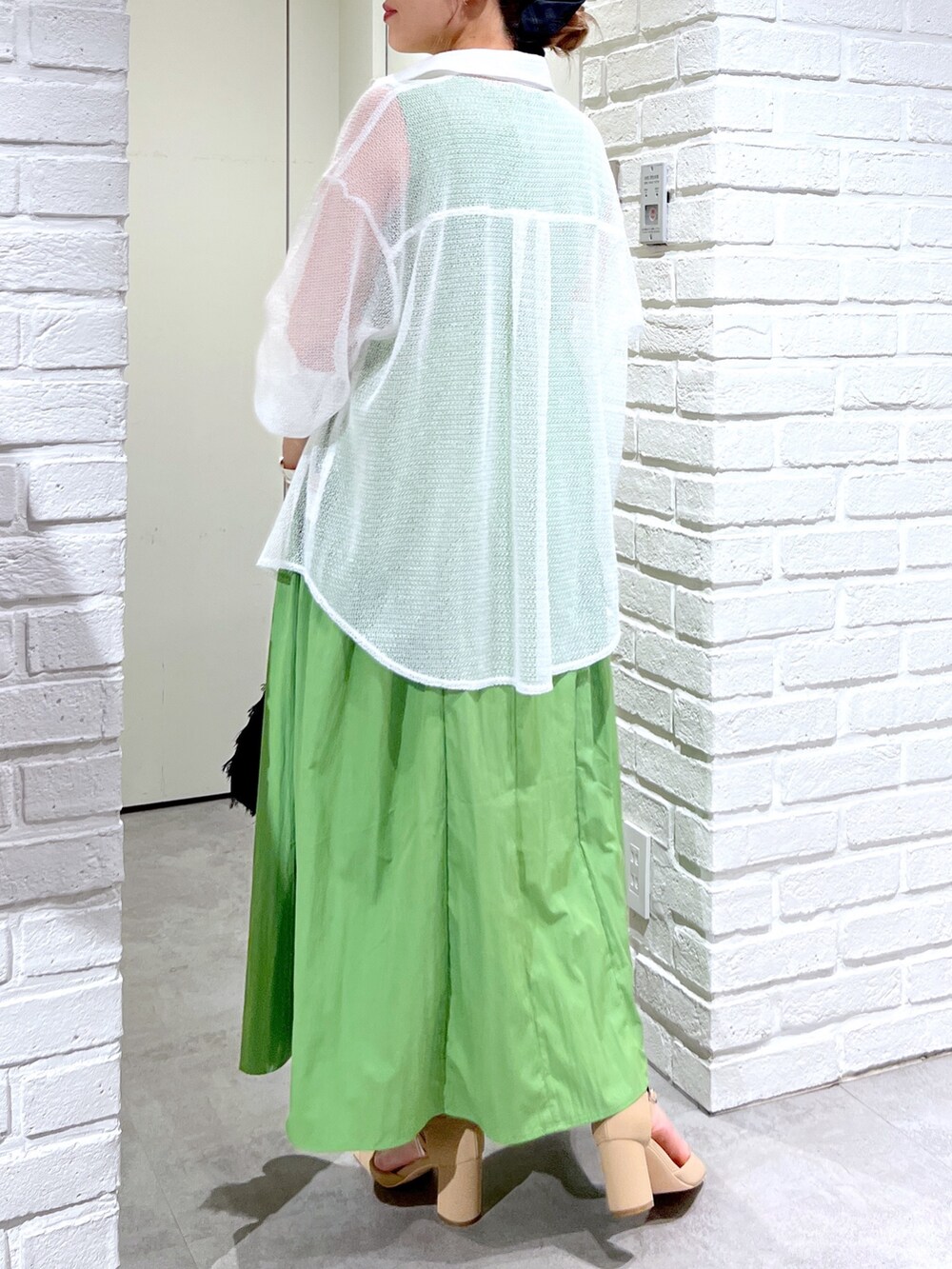 グリーン系のワンピース、ホワイト系のシャツ/ブラウス、ブラック系のハンドバッグを着用したレディースの夏コーディネートの6枚目の写真