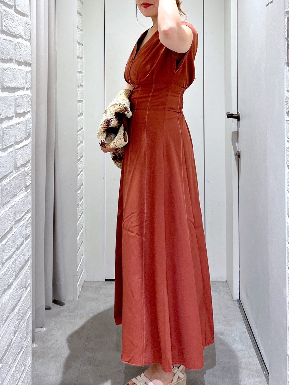 ブラウン系のワンピース、ベージュ系のトートバッグ、ホワイト系のサンダルを着用したレディースの夏コーディネートの6枚目の写真