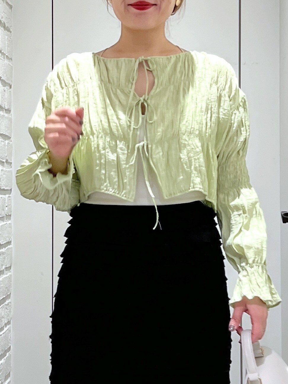 ブラック系のスカート、グリーン系のシャツ/ブラウス、ホワイト系のショルダーバッグを着用したレディースの春コーディネートの5枚目の写真