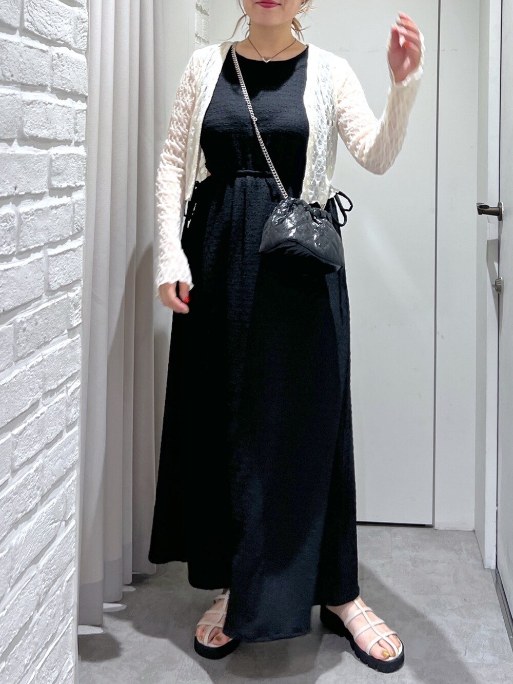 ブラック系のワンピース、ホワイト系のカーディガン/ボレロ、ホワイト系のサンダルを着用したレディースの夏コーディネートの5枚目の写真