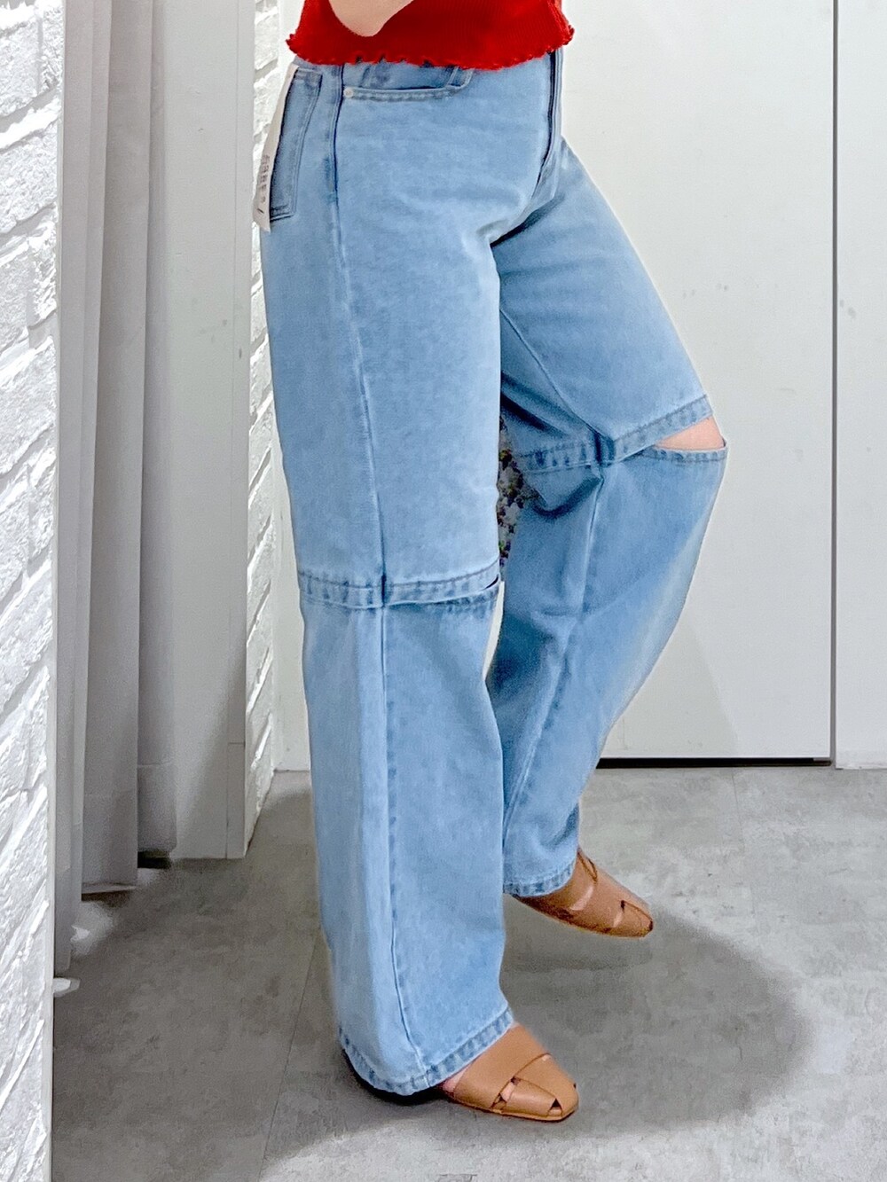 レッド系のニット/セーター、ブルー系のデニムパンツ、ベージュ系のスリッポンを着用したレディースの夏コーディネートの7枚目の写真