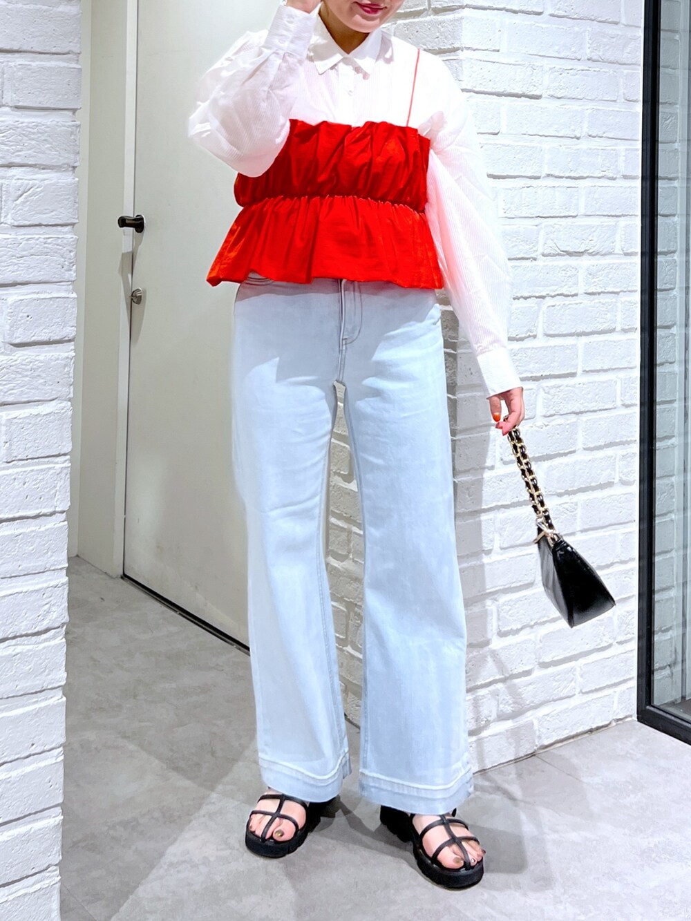 ブルー系のデニムパンツ、ブラック系のサンダル、レッド系のシャツ/ブラウスを着用したレディースの夏コーディネートの5枚目の写真