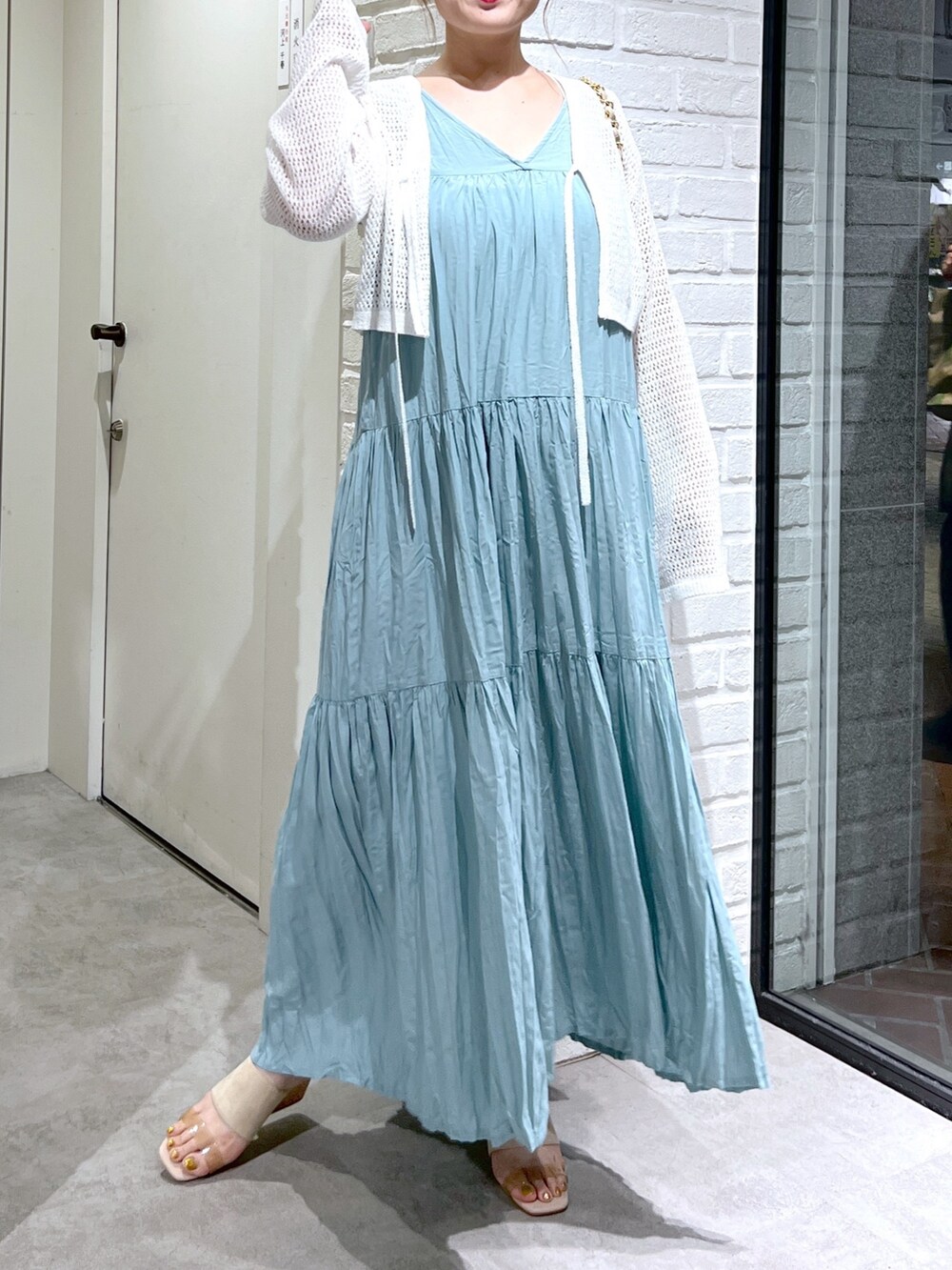 ホワイト系のカーディガン/ボレロ、グリーン系のワンピース、グレー系のサンダルを着用したレディースの夏コーディネートの5枚目の写真