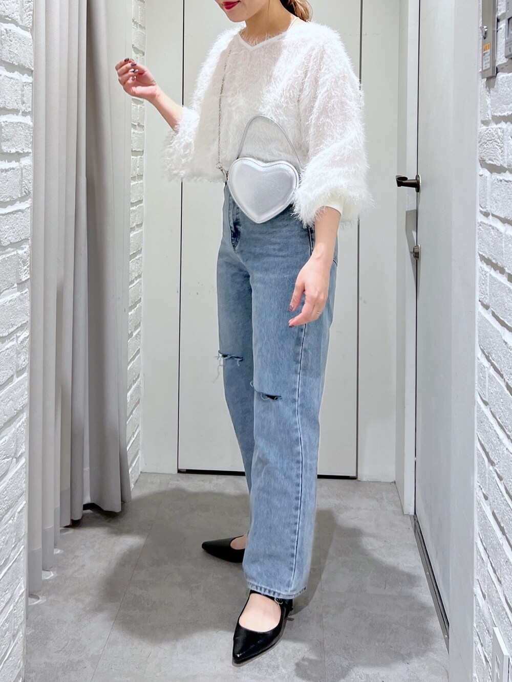 ブルー系のデニムパンツ、ホワイト系のシャツ/ブラウス、シルバー系のショルダーバッグを着用したレディースの春コーディネートの2枚目の写真