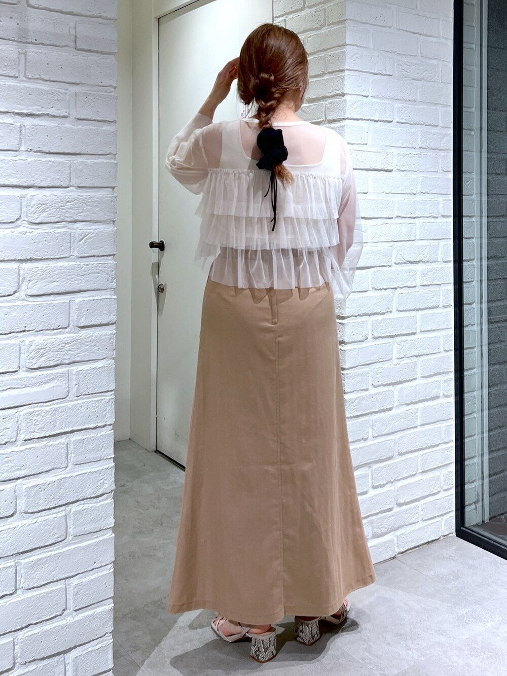 ブラウン系のスカート、ブラック系のハンドバッグ、グレー系のサンダルを着用したレディースの夏コーディネートの4枚目の写真