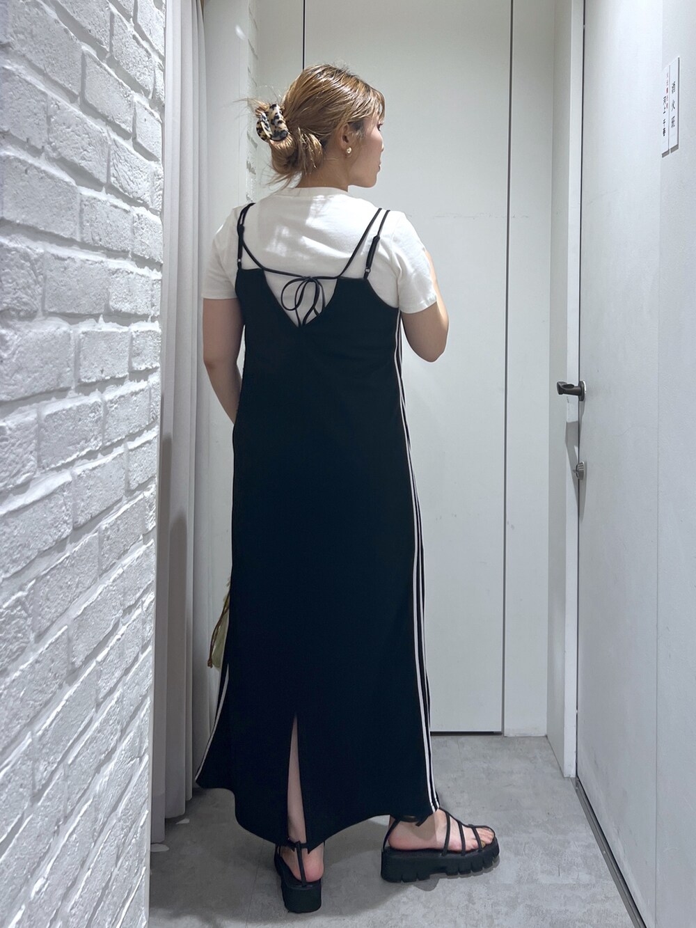 ブラック系のワンピース、ホワイト系のTシャツ/カットソー、ブラック系のサンダルを着用したレディースの夏コーディネートの3枚目の写真