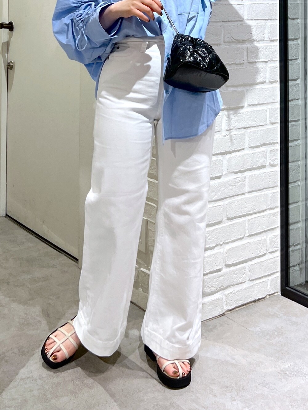 ブルー系のシャツ/ブラウス、ブラック系のショルダーバッグ、ホワイト系のデニムパンツを着用したレディースの夏コーディネートの8枚目の写真