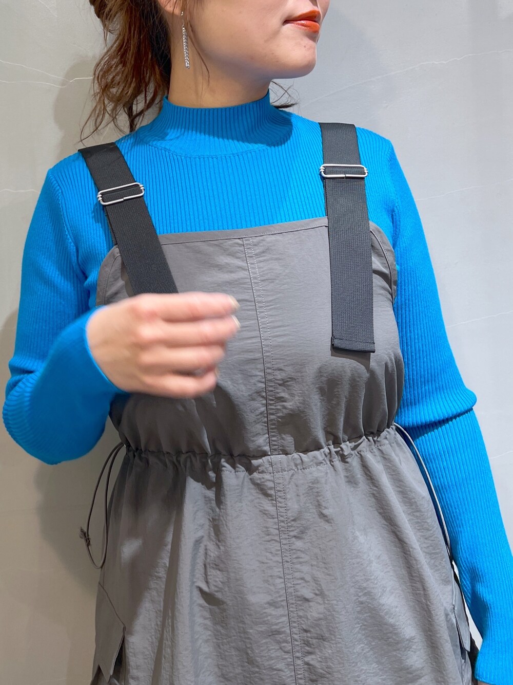 グレー系のワンピース、ブラック系のハンドバッグ、ブラック系のブーツを着用したレディースの冬コーディネートの8枚目の写真