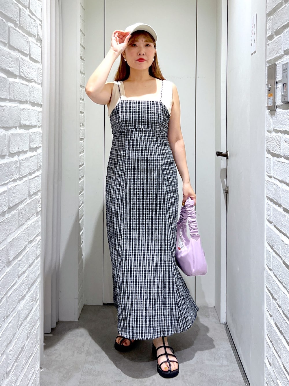 パープル系のハンドバッグ、ブラック系のサンダル、ホワイト系のカーディガン/ボレロを着用したレディースの夏コーディネートの5枚目の写真