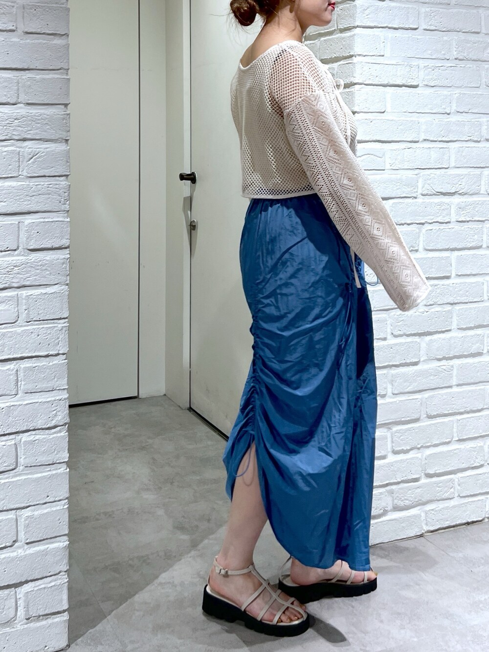 ブルー系のスカート、ホワイト系のカーディガン/ボレロ、ホワイト系のサンダルを着用したレディースの夏コーディネートの5枚目の写真