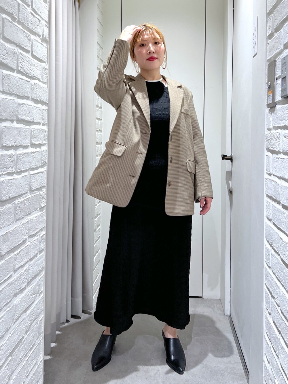 ブラック系のワンピース、ブラック系のパンプス、ゴールド系のショルダーバッグを着用したレディースの春コーディネートの8枚目の写真