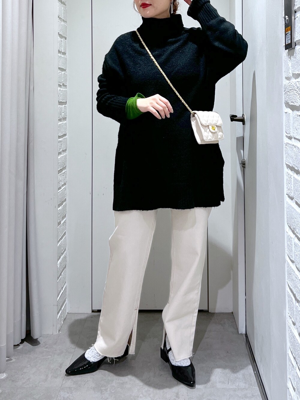 ブラック系のニット/セーター、ホワイト系のデニムパンツ、ブラック系のバレエシューズを着用したレディースの冬コーディネートの4枚目の写真