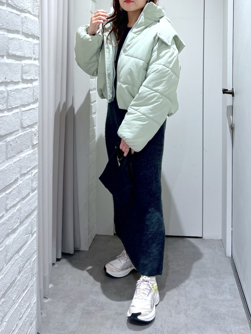 ブラック系のワンピース、グリーン系のブルゾン、ブラック系のショルダーバッグを着用したレディースの冬コーディネートの4枚目の写真