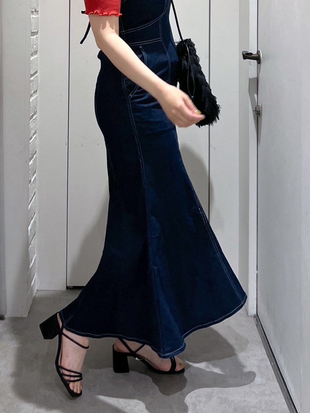 ブラック系のハンドバッグ、ブルー系のワンピース、レッド系のニット/セーターを着用したレディースの夏コーディネートの6枚目の写真