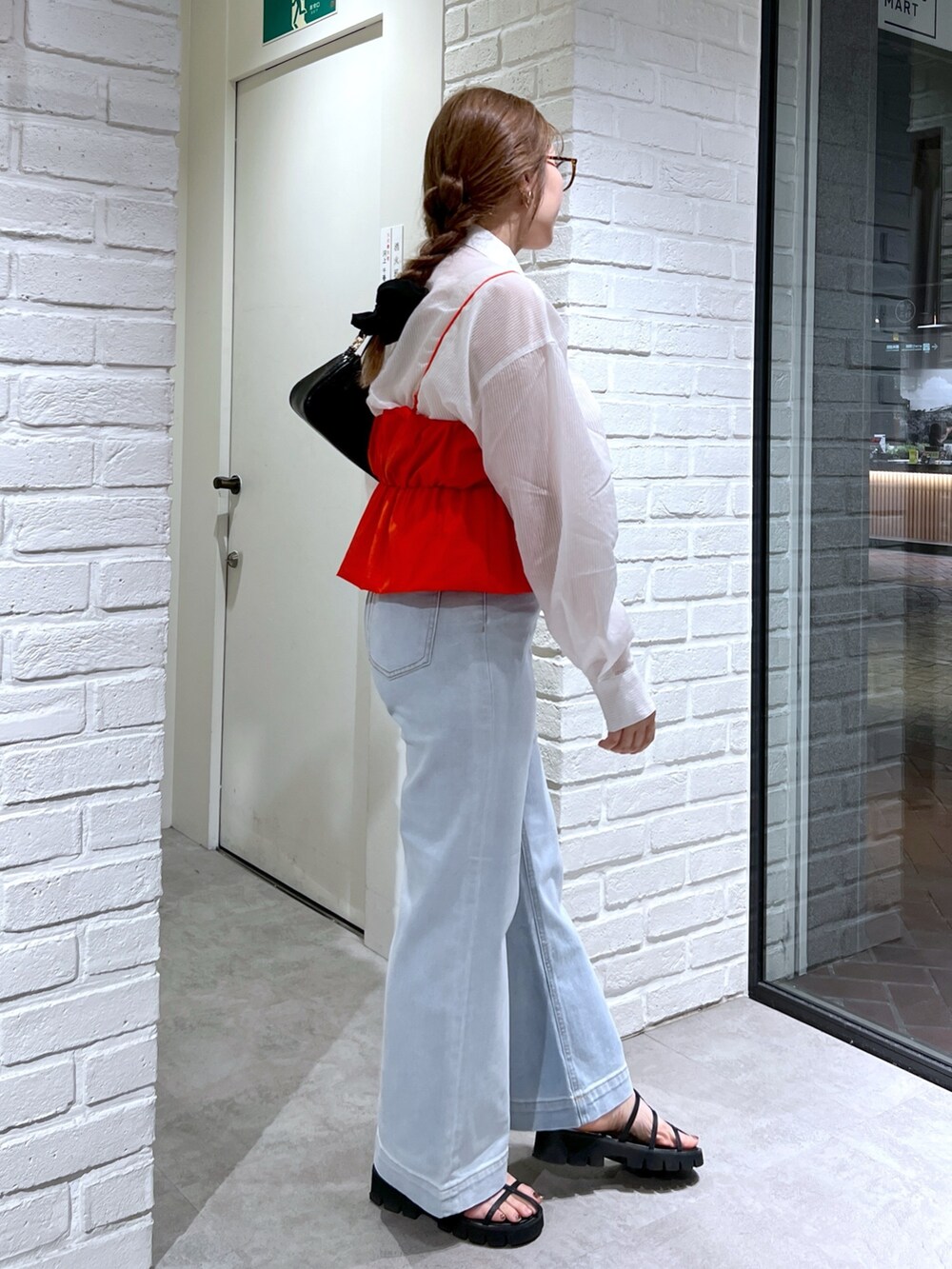 ブルー系のデニムパンツ、ブラック系のサンダル、レッド系のシャツ/ブラウスを着用したレディースの夏コーディネートの4枚目の写真