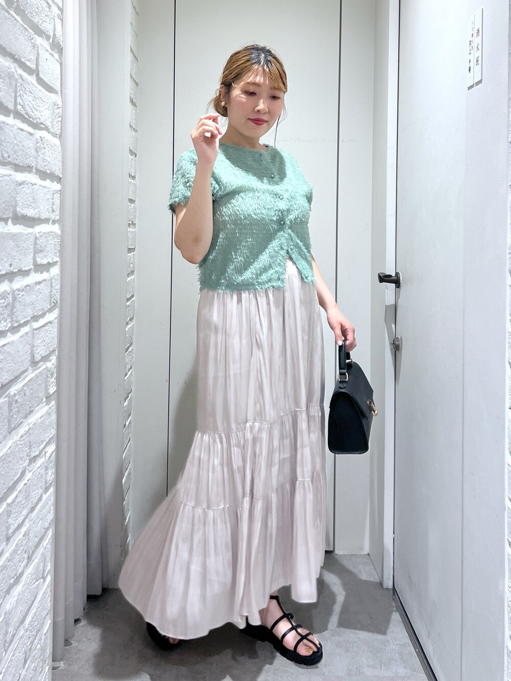 ホワイト系のスカート、グリーン系のシャツ/ブラウス、ブラック系のショルダーバッグを着用したレディースの夏コーディネートの5枚目の写真