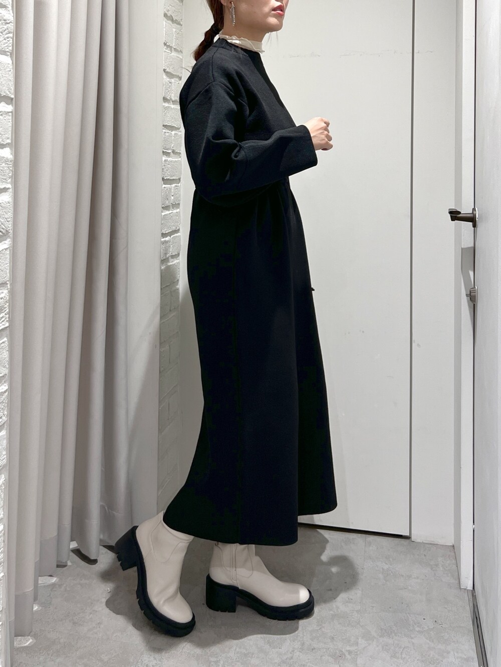 ブラック系のワンピース、ホワイト系のTシャツ/カットソー、ブラック系のハンドバッグを着用したレディースの秋コーディネートの5枚目の写真