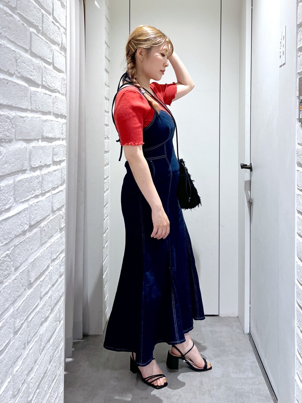 ブラック系のハンドバッグ、ブルー系のワンピース、レッド系のニット/セーターを着用したレディースの夏コーディネートの2枚目の写真