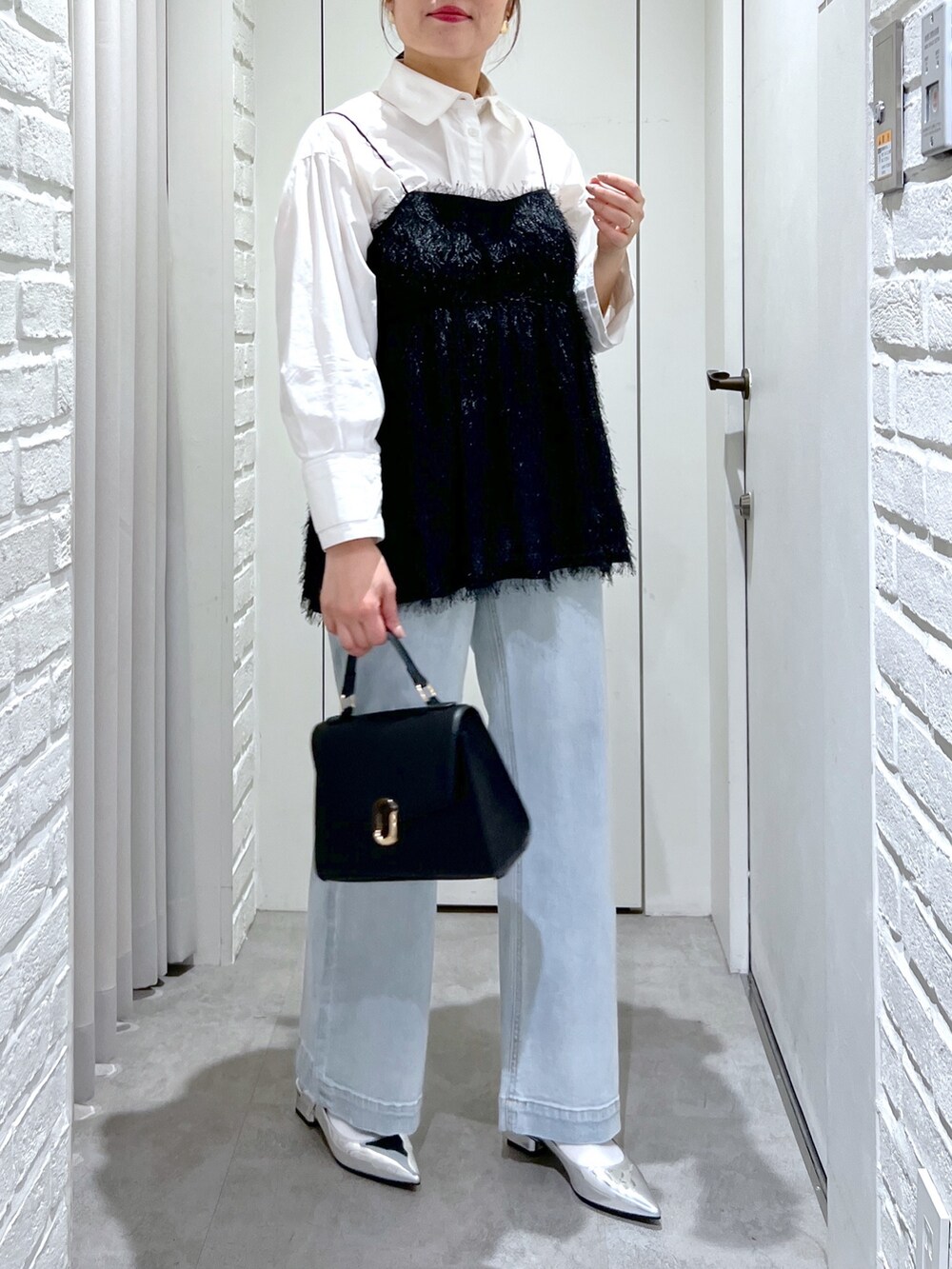 ブラック系のシャツ/ブラウス、ブルー系のデニムパンツ、シルバー系のパンプスを着用したレディースの冬コーディネートの5枚目の写真