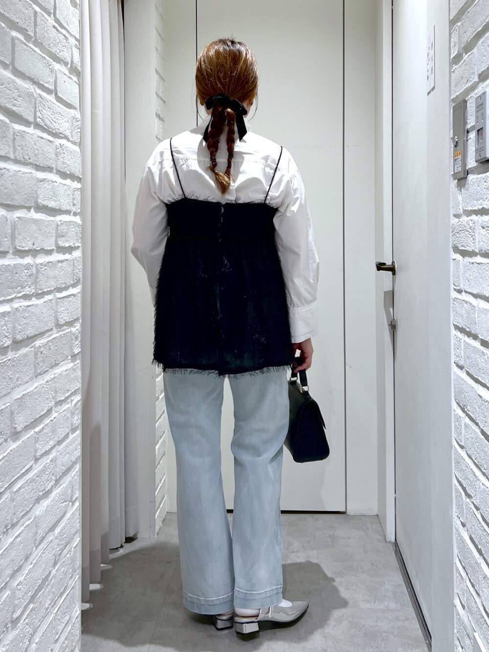 ブラック系のシャツ/ブラウス、ブルー系のデニムパンツ、シルバー系のパンプスを着用したレディースの冬コーディネートの6枚目の写真