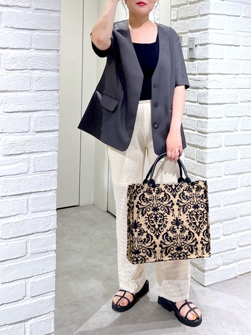 ホワイト系のその他パンツ、グレー系のノーカラージャケット、ブラック系のタンクトップを着用したレディースの夏コーディネートの3枚目の写真