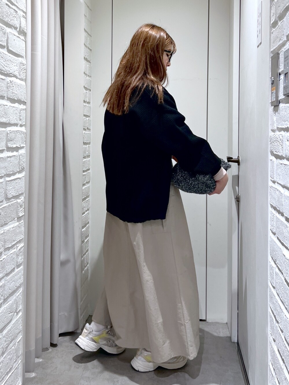 ベージュ系のワンピース、ブラック系のトートバッグ、ブラック系のカーディガン/ボレロを着用したレディースの冬コーディネートの3枚目の写真