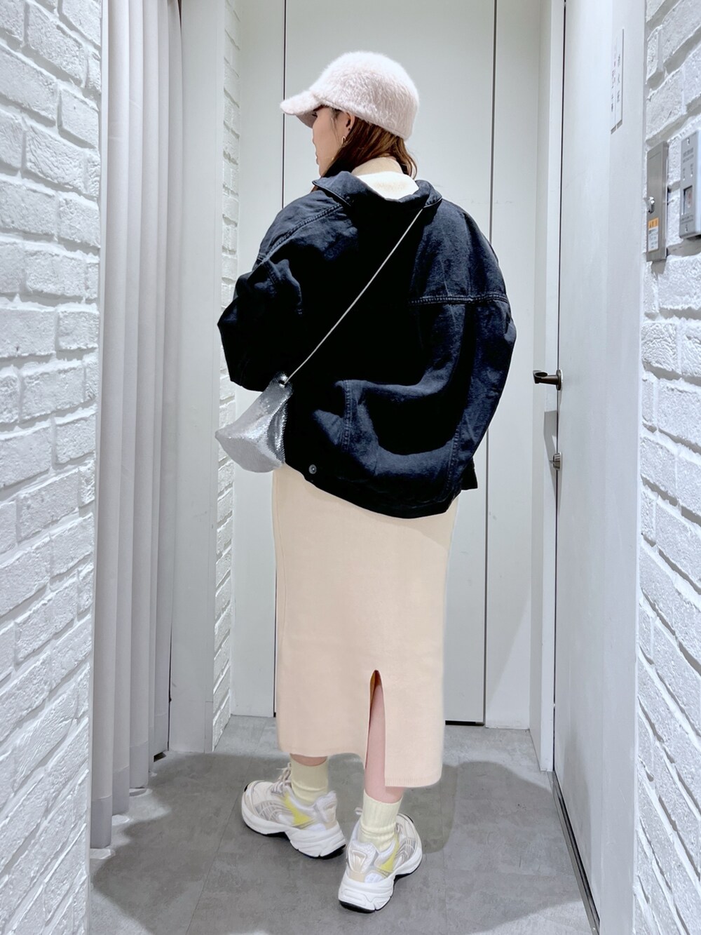 ホワイト系のワンピース、シルバー系のショルダーバッグ、ブラック系のデニムジャケットを着用したレディースの冬コーディネートの4枚目の写真