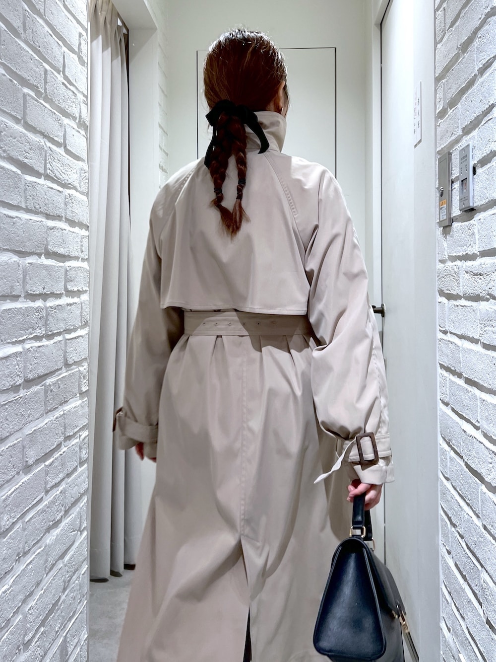 ベージュ系のトレンチコート、ブラック系のショルダーバッグ、ブルー系のデニムパンツを着用したレディースの春コーディネートの8枚目の写真