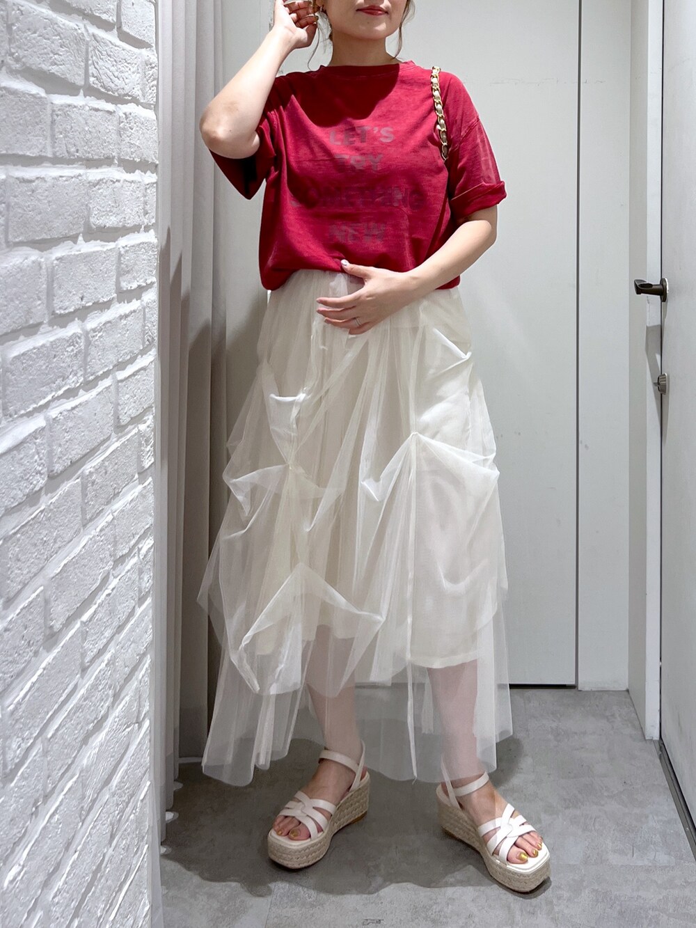 ホワイト系のスカート、レッド系のTシャツ/カットソー、ホワイト系のサンダルを着用したレディースの夏コーディネートの5枚目の写真
