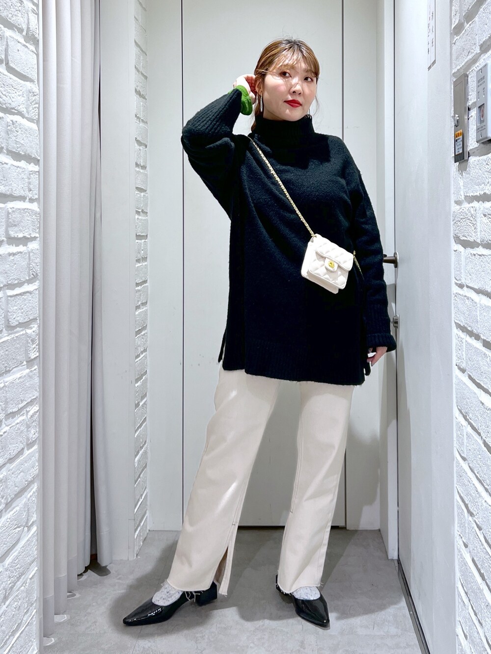 ブラック系のニット/セーター、ホワイト系のデニムパンツ、ブラック系のバレエシューズを着用したレディースの冬コーディネートの3枚目の写真