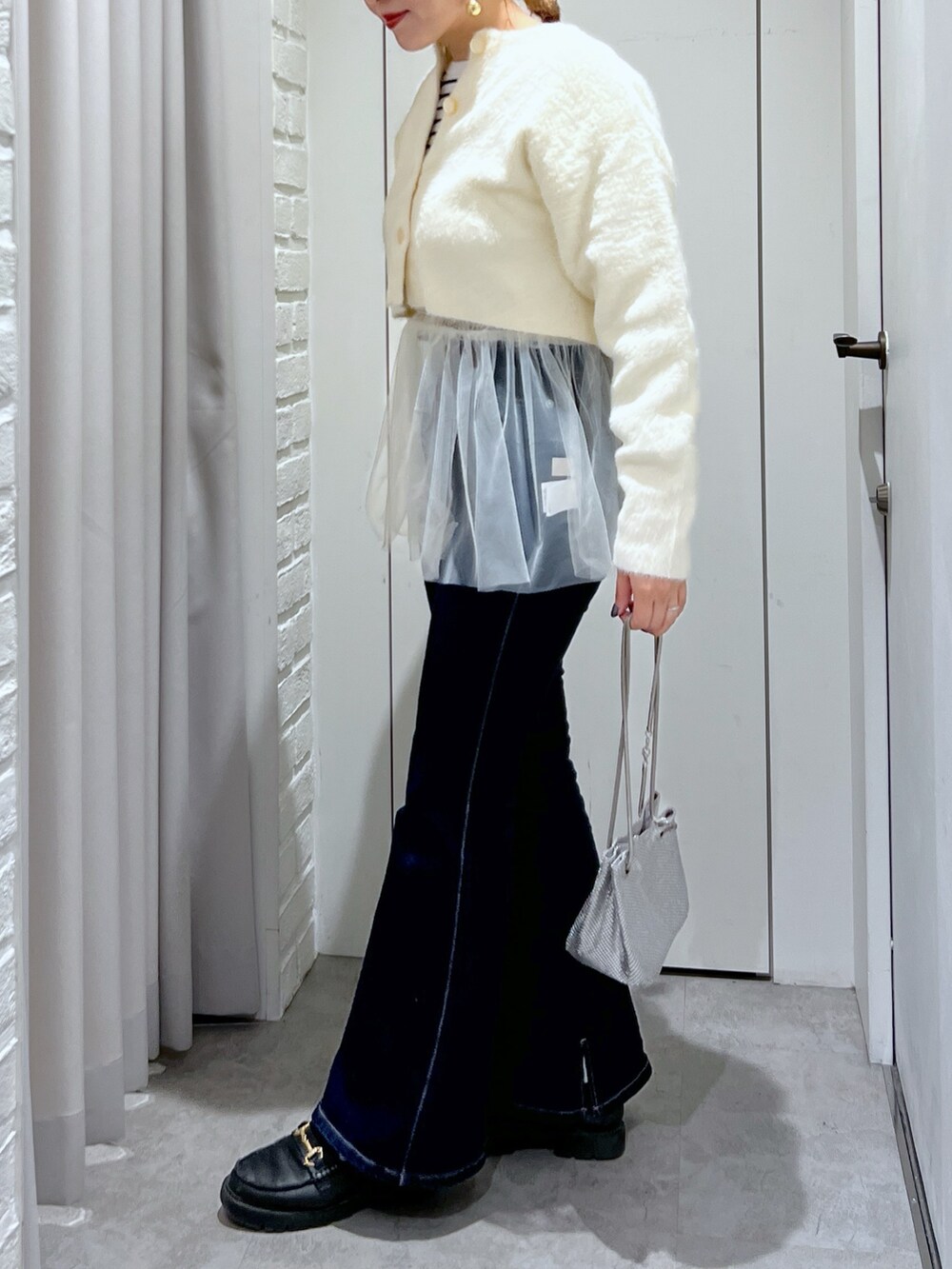 ホワイト系のシャツ/ブラウス、ホワイト系のカーディガン/ボレロ、ブルー系のデニムパンツを着用したレディースの冬コーディネートの3枚目の写真