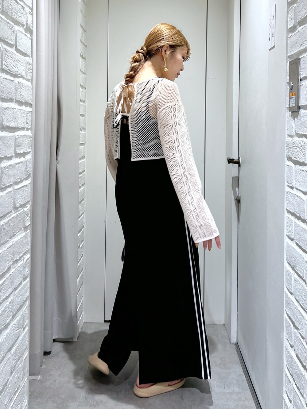 ブラック系のワンピース、ホワイト系のカーディガン/ボレロ、ブラック系のトートバッグを着用したレディースの夏コーディネートの3枚目の写真