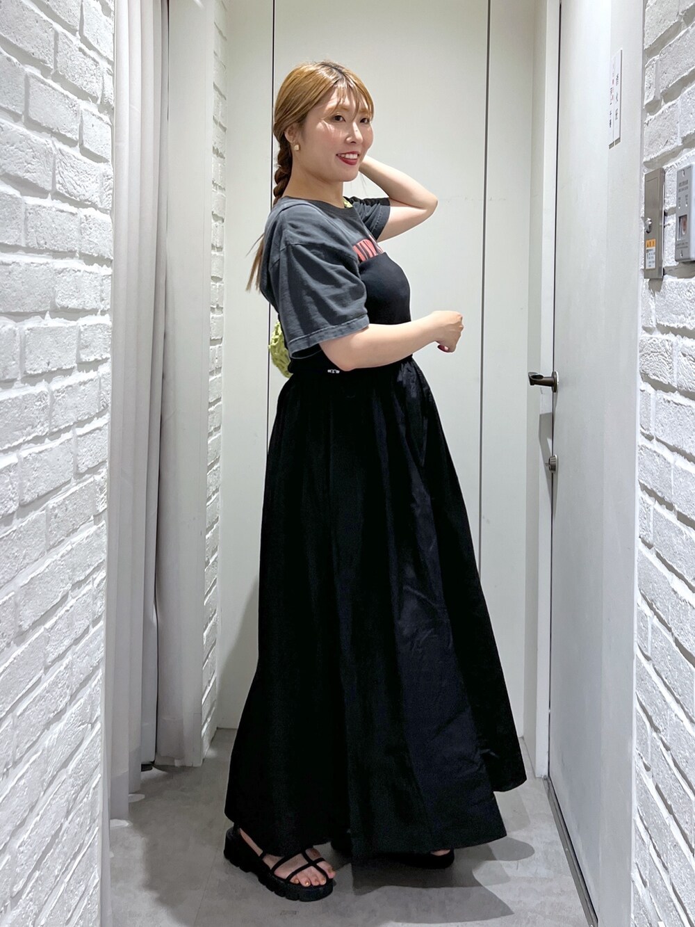 ブラック系のワンピース、ブラック系のTシャツ/カットソー、グリーン系のかごバッグを着用したレディースの夏コーディネートの3枚目の写真